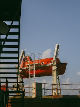 Orange lifeboat mounted on a ship in Derepazarı, Rize, Türkiye, with clear sky.