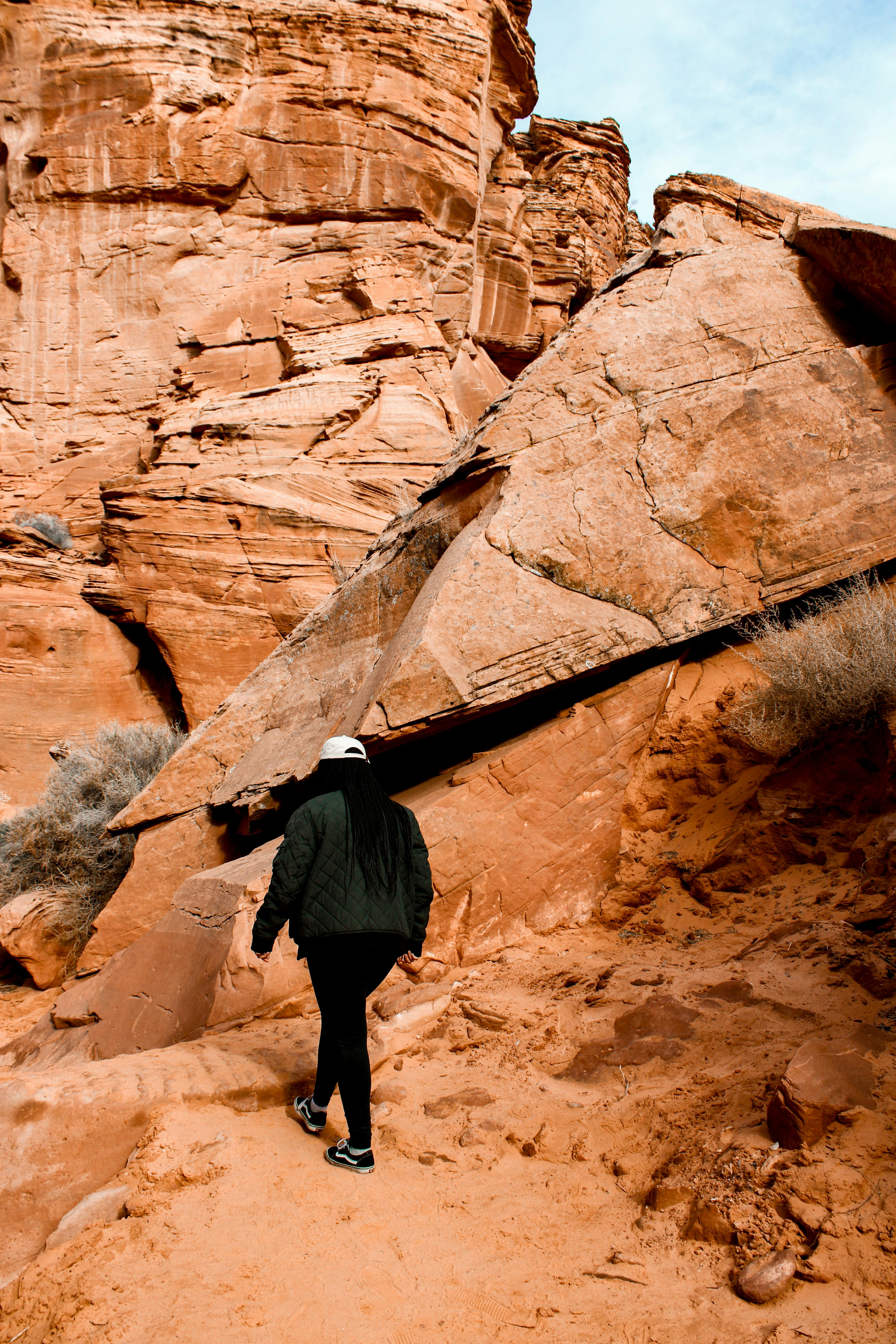 A person hikes through the majestic red rock formations of Arizona, showcasing natural beauty.