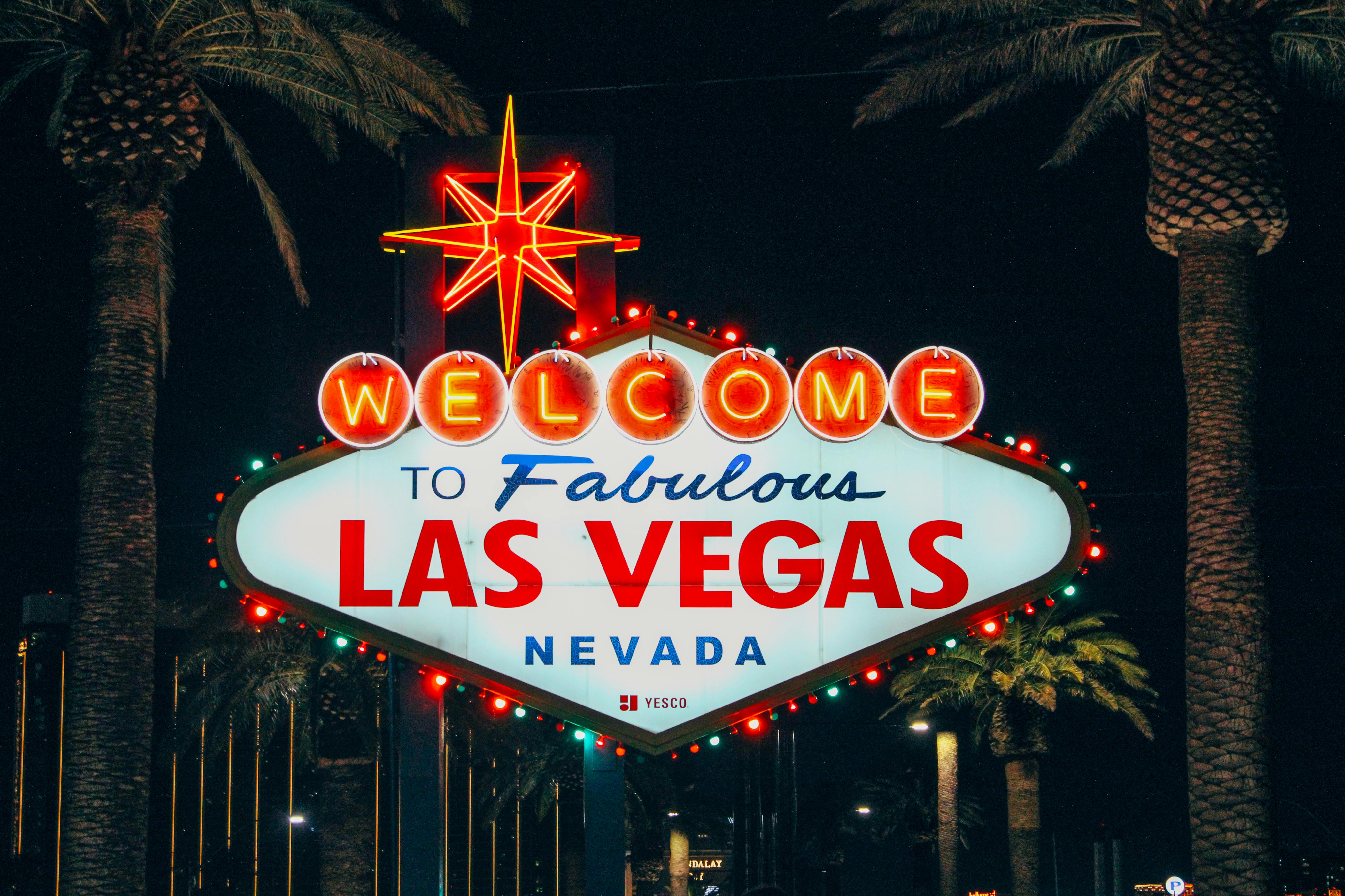 Free The iconic Welcome to Fabulous Las Vegas sign illuminated at night with palm trees in the background. Stock Photo