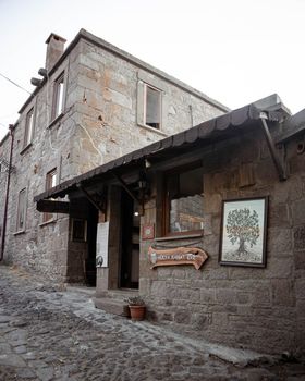 Charming stone house with vintage architectural details on a cobblestone street in a rustic setting. — photo by Emre  Simsek
