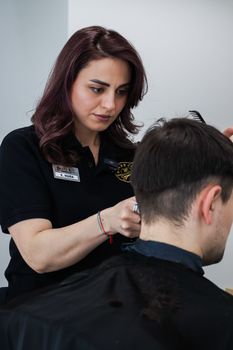 A skilled hairdresser expertly cutting a client's hair in a salon setting.
