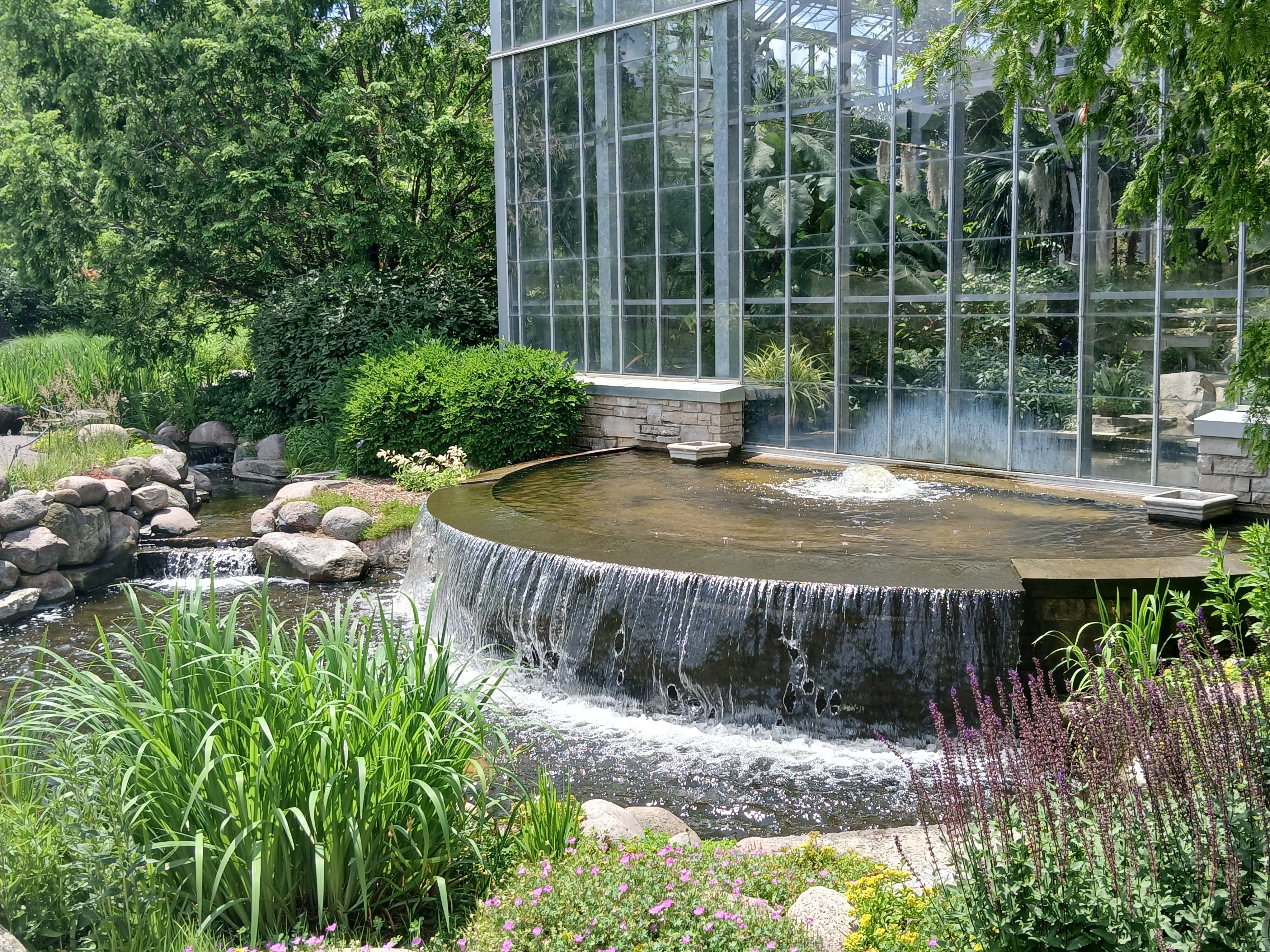 Rockford: Waterfall beside a glass conservatory surrounded by lush gardens