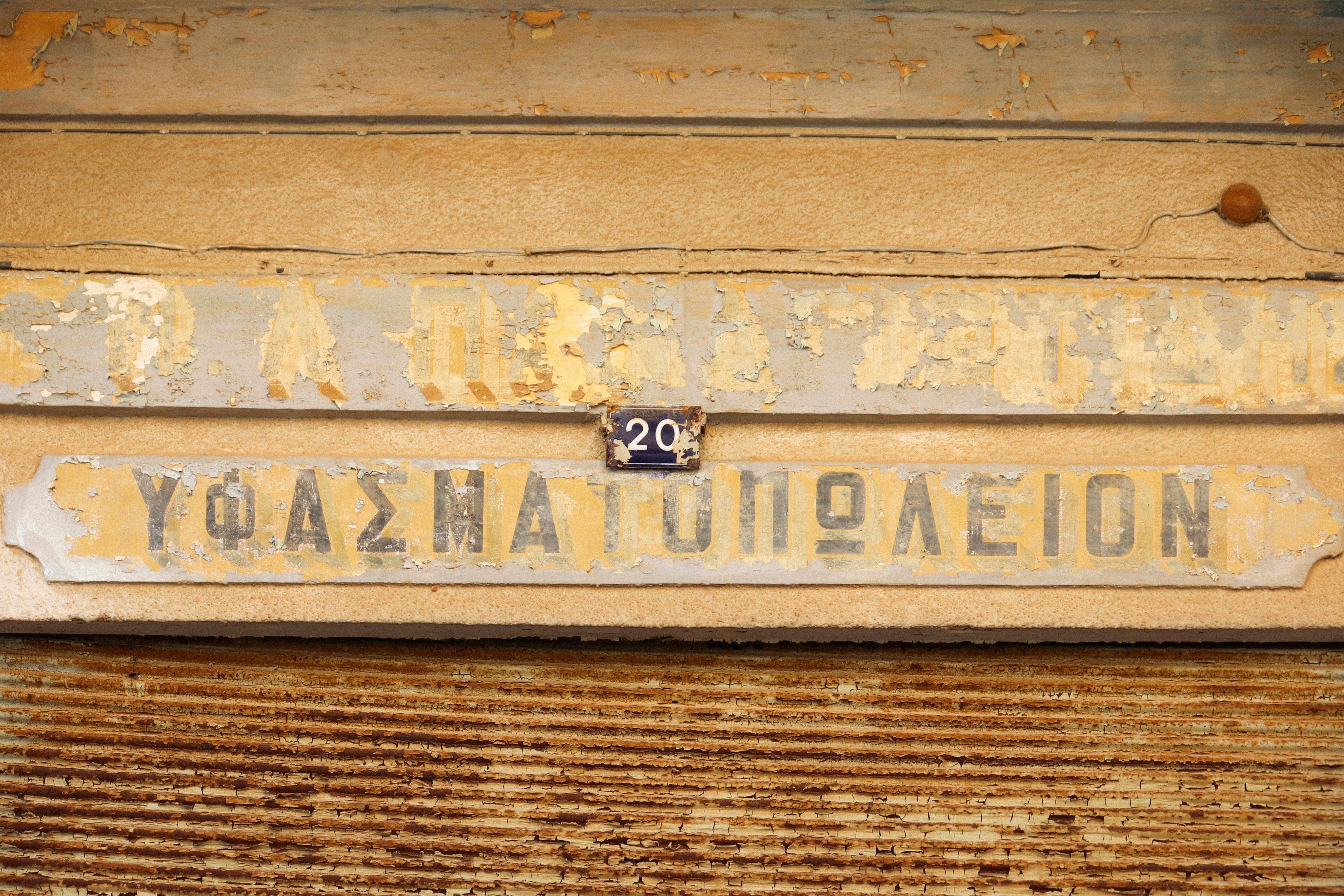 Aged shop sign with peeling paint in Gazimağusa, offering a vintage look. - Photo by muaz semih güven on Pexels