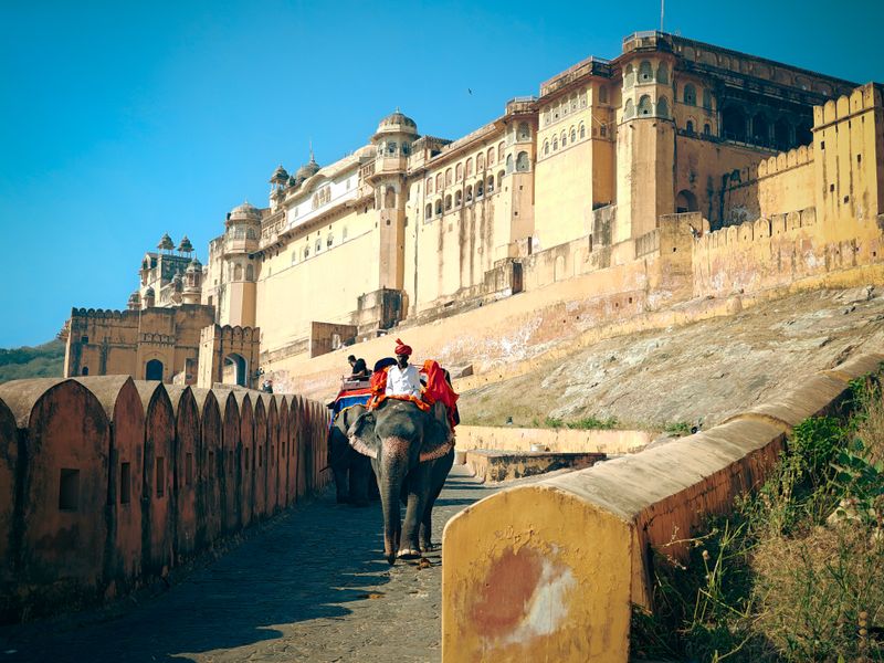 Tourists enjoy an elephant ride at Amber Fort, a majestic Rajasthan landmark.