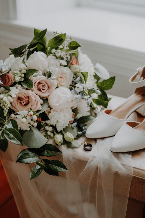Free Chic floral bouquet with bridal shoes and wedding rings, symbolizing a romantic wedding setting. Stock Photo