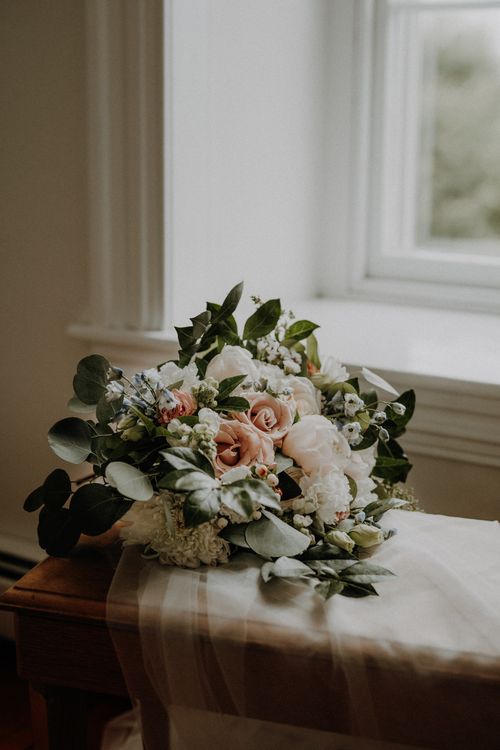Free Beautiful rose and eucalyptus bouquet elegantly displayed by a sunlit window. Stock Photo