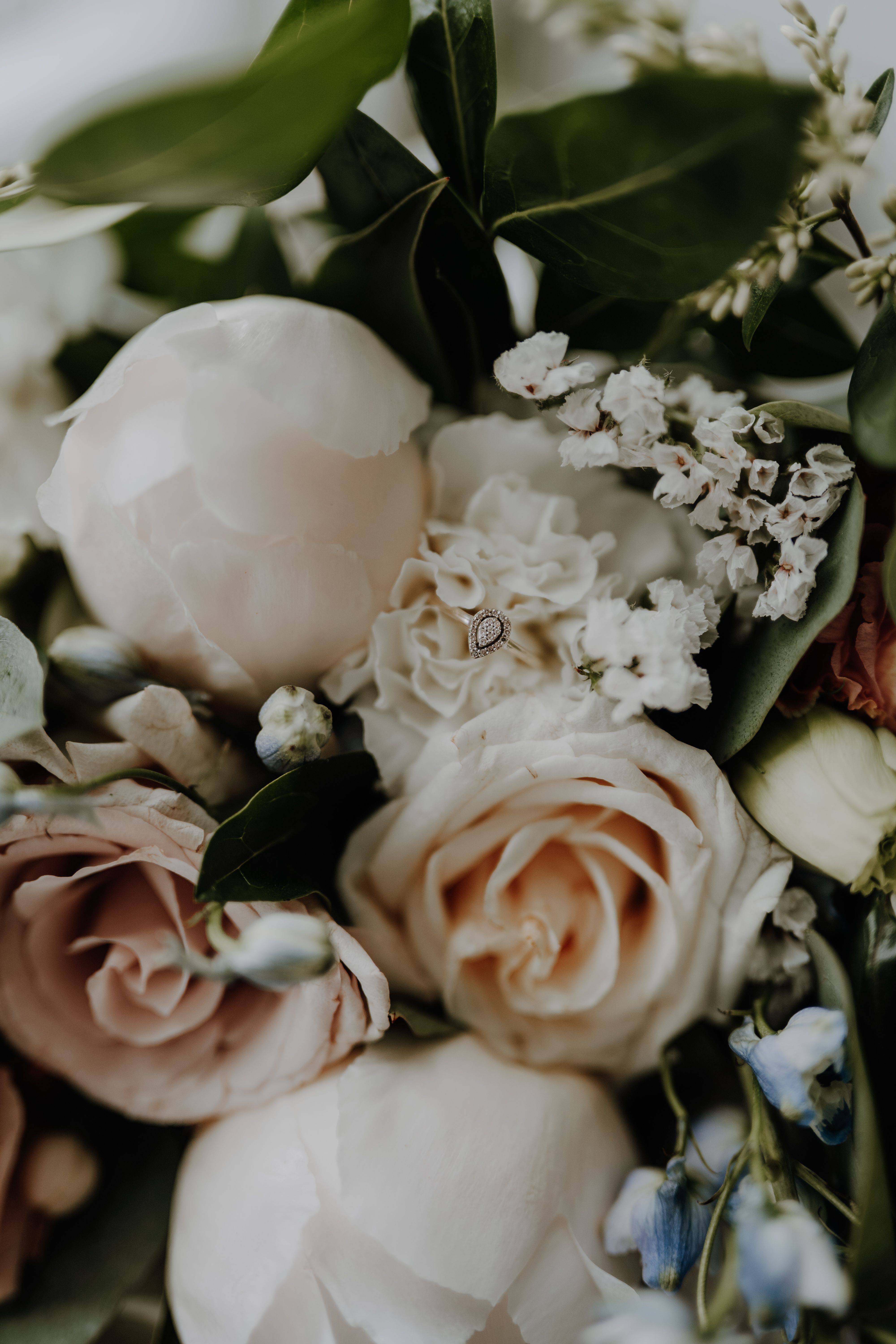 Delicate bridal bouquet featuring roses and an engagement ring