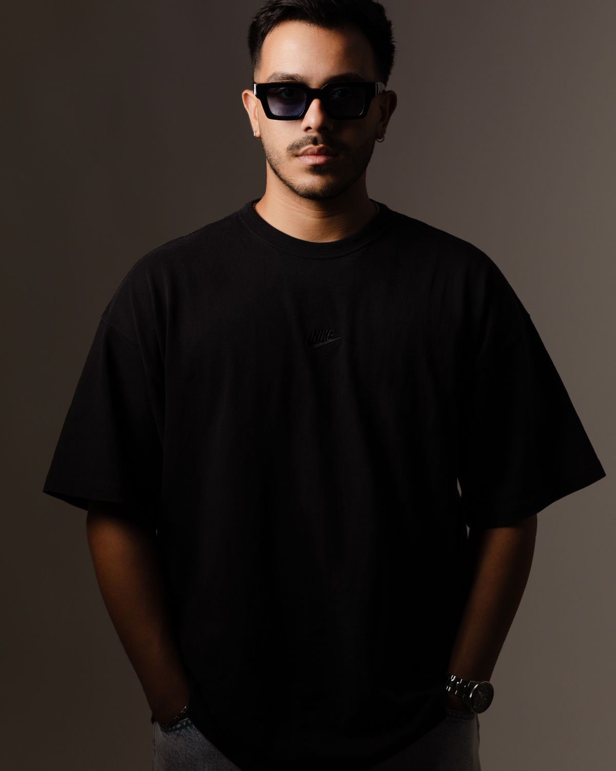 Minimal dark studio portrait wearing the signature collection