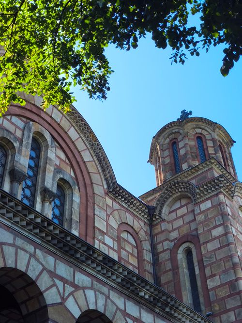 Free Byzantine-style church facade with stone arches under clear blue sky. Stock Photo