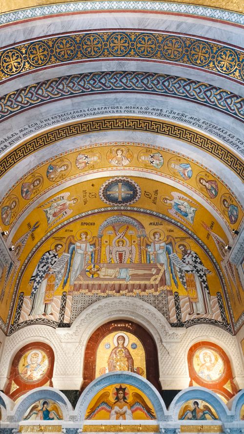 Free Detailed mosaic artwork on a church ceiling featuring religious imagery and rich colors. Stock Photo