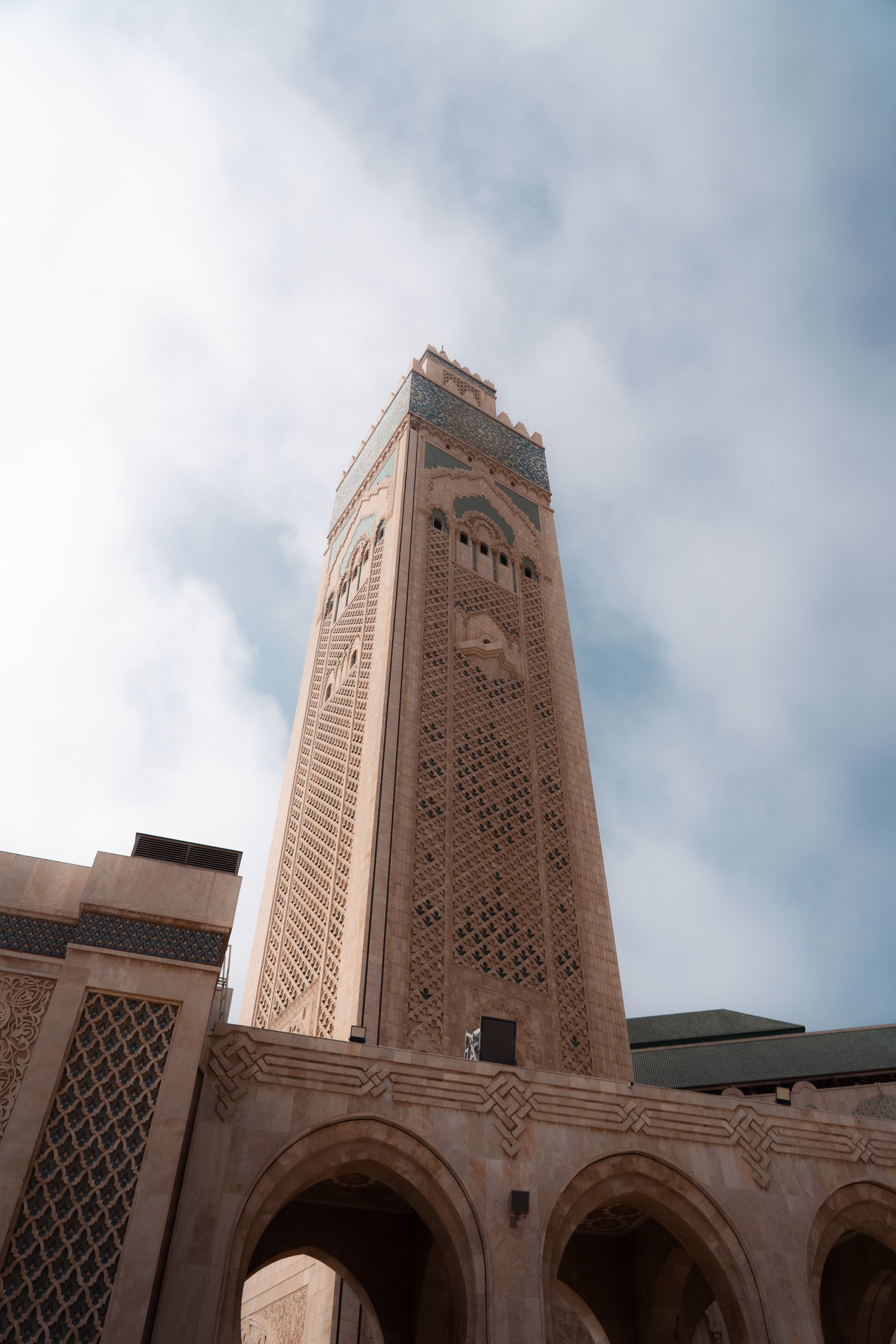 Majestic view of Hassan II Mosque minaret against blue sky.