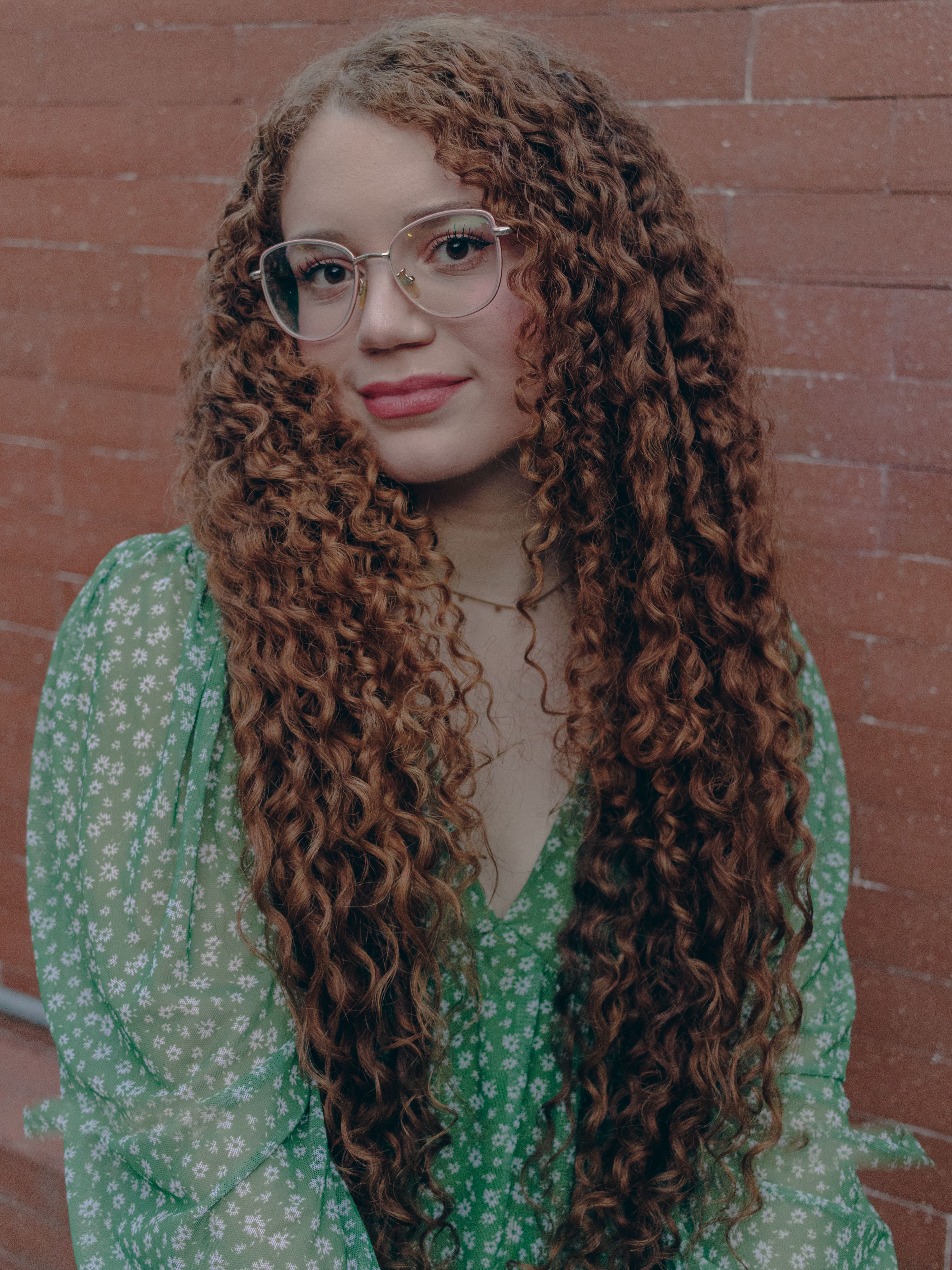 Portrait of a Woman with Curly Hair and Glasses · Free Stock Photo