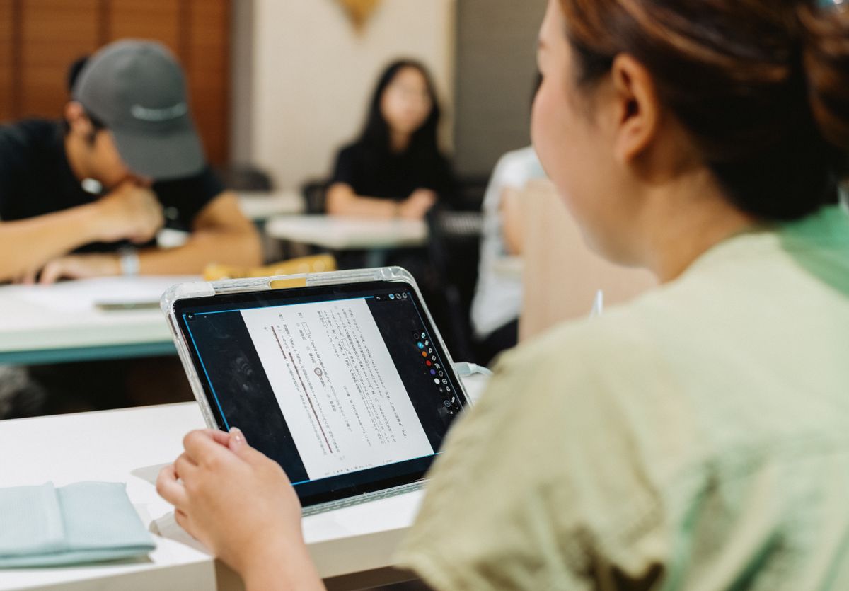 Students in Japanese classroom using tablet for digital learning