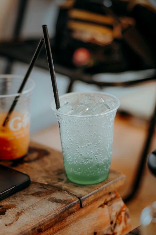Free Chilled green soda with ice in a plastic cup, perfect for a refreshing outdoor drink. Stock Photo