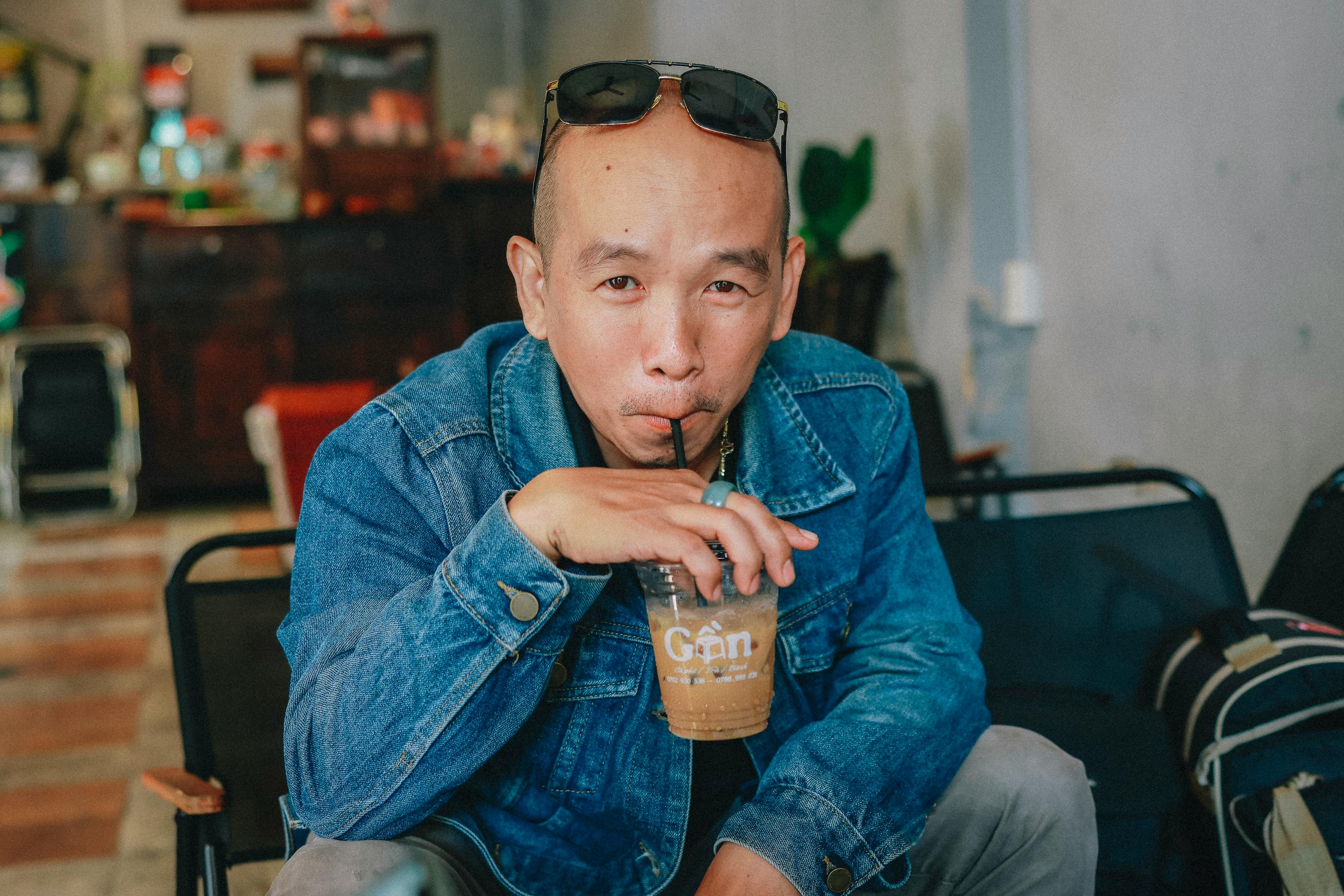 무료 아늑한 실내 카페에서 아이스커피를 마시는 캐주얼한 남자. 스톡 사진