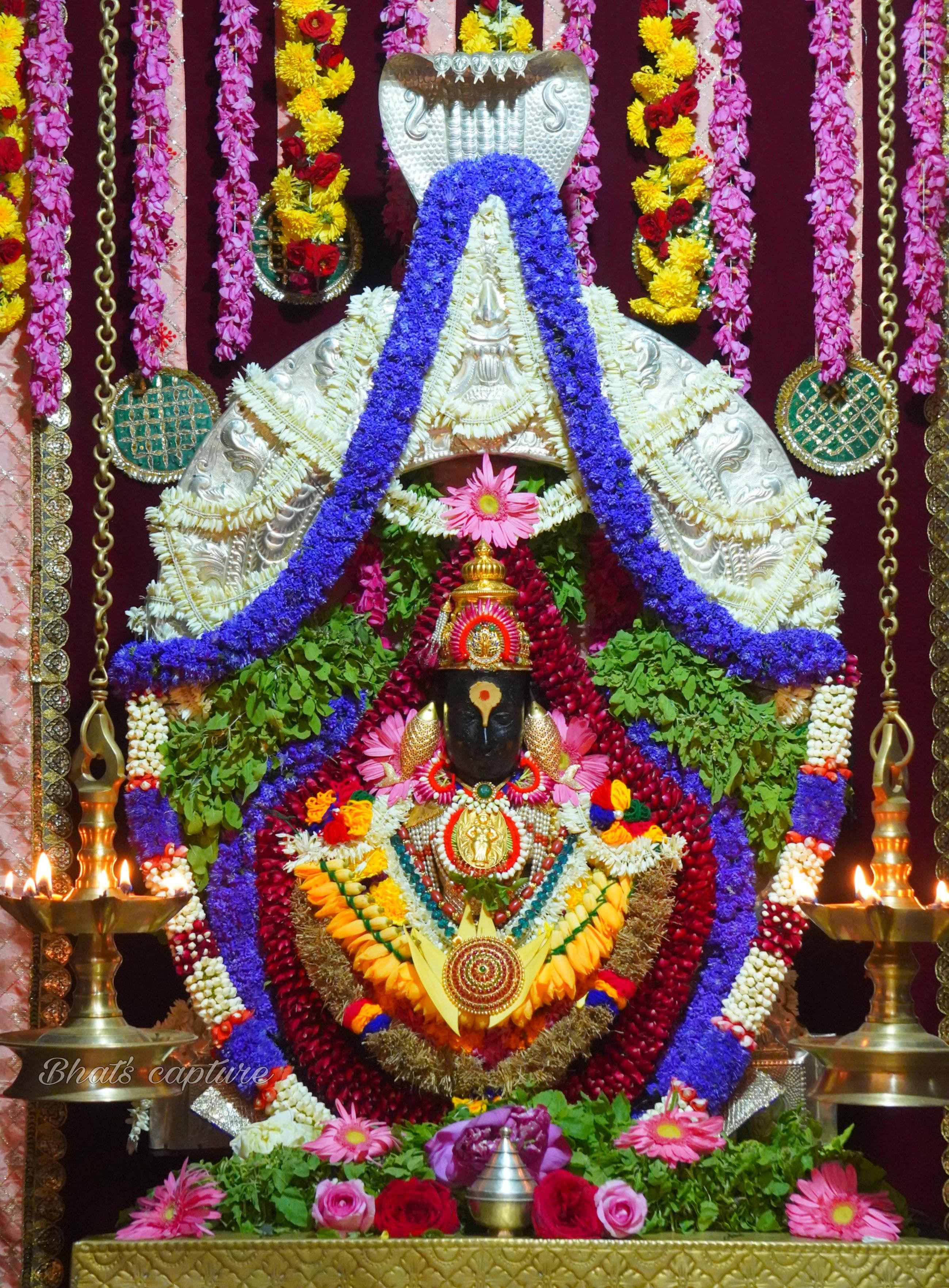 Beautifully adorned Hindu idol with vibrant flower garlands and traditional decor.