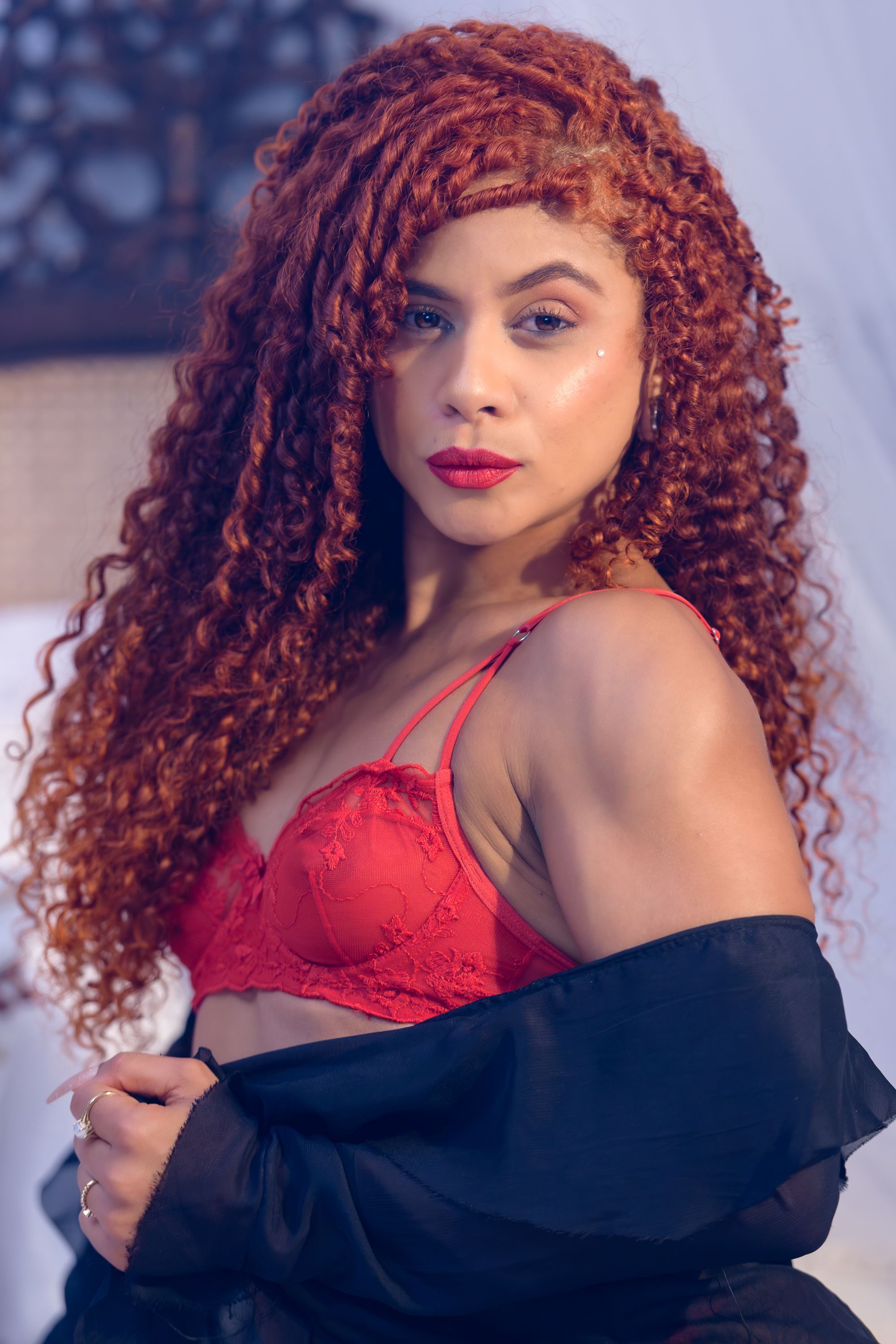 Retrato elegante de uma mulher com cabelos ruivos e lingerie, exalando confiança e estilo.