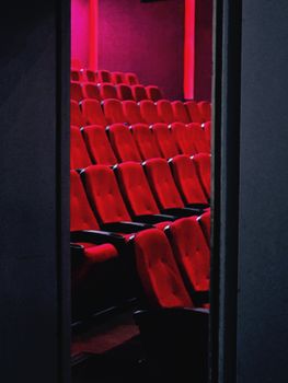 A view of empty red theater seats in a dimly lit cinema in Tehran, Iran.