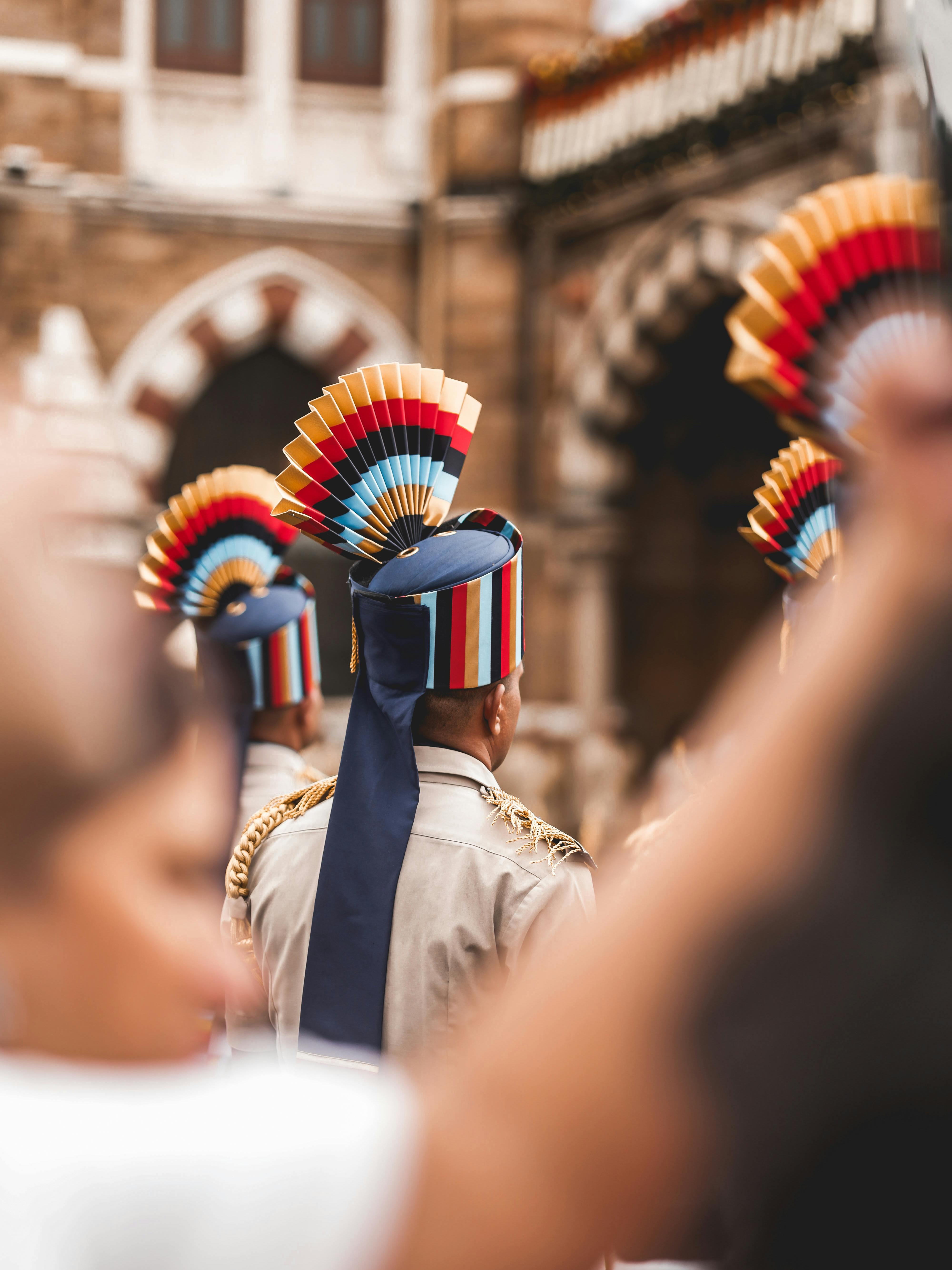 Vibrant attire of Indian guards in front of historic architecture; cultural representation.