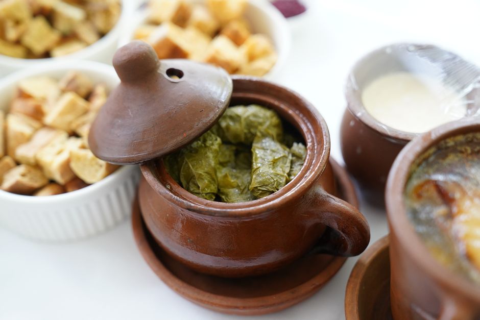 Photo by Tahir Xəlfəquliyev on Pexels Delicious dolma served in a rustic clay pot with bread and yogurt sides for an authentic meal. - Photo by Tahir Xəlfəquliyev on Pexels