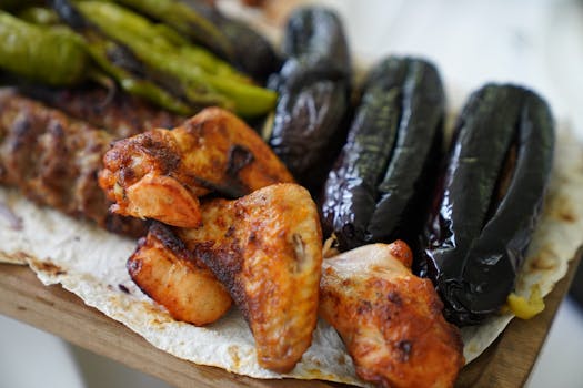 A close-up of grilled chicken wings and vegetables on flatbread, showcasing hearty flavors.