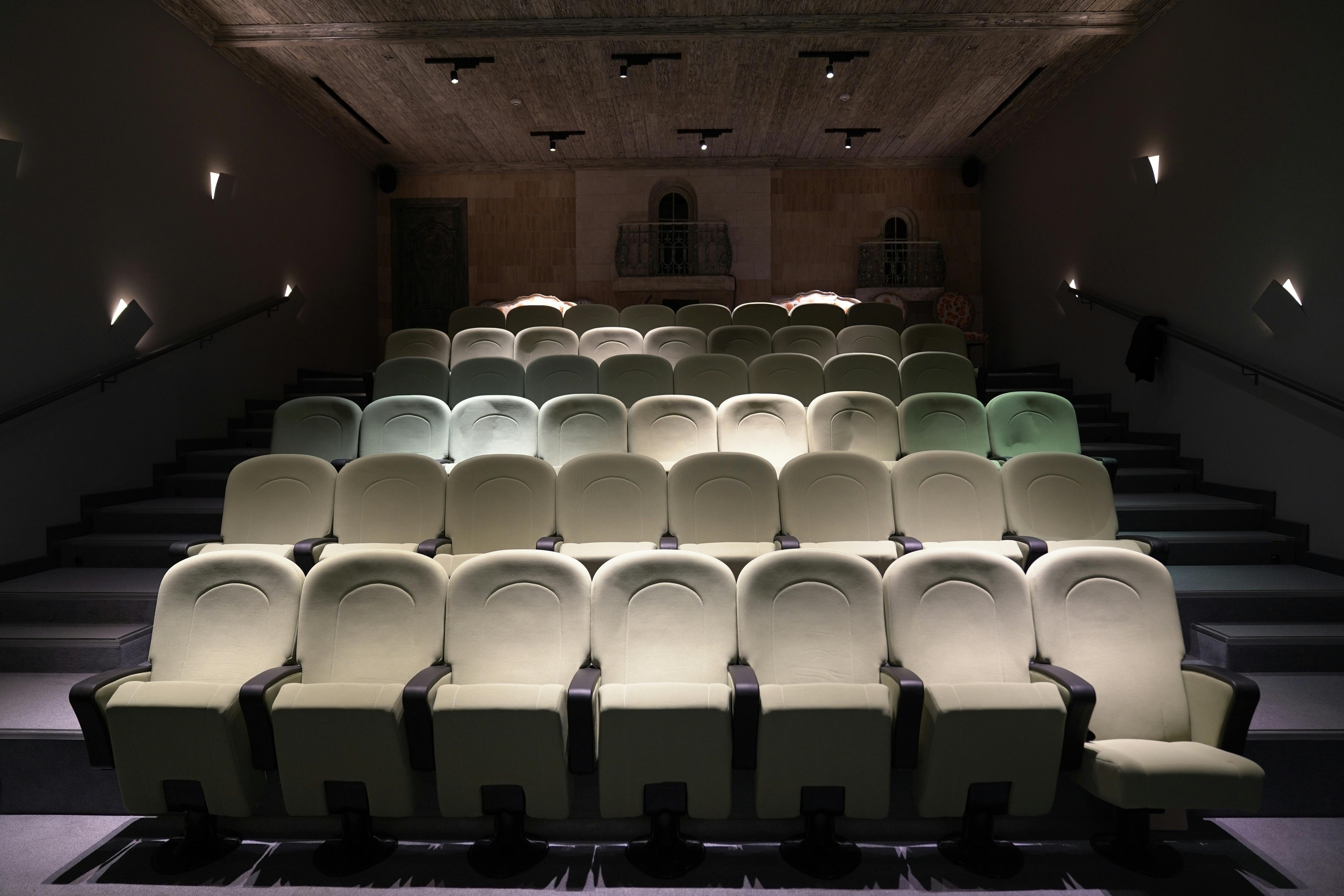 De franc Un teatre buit amb seients de luxe ben disposats i una il·luminació subtil, que crea un ambient íntim. Foto d'estoc