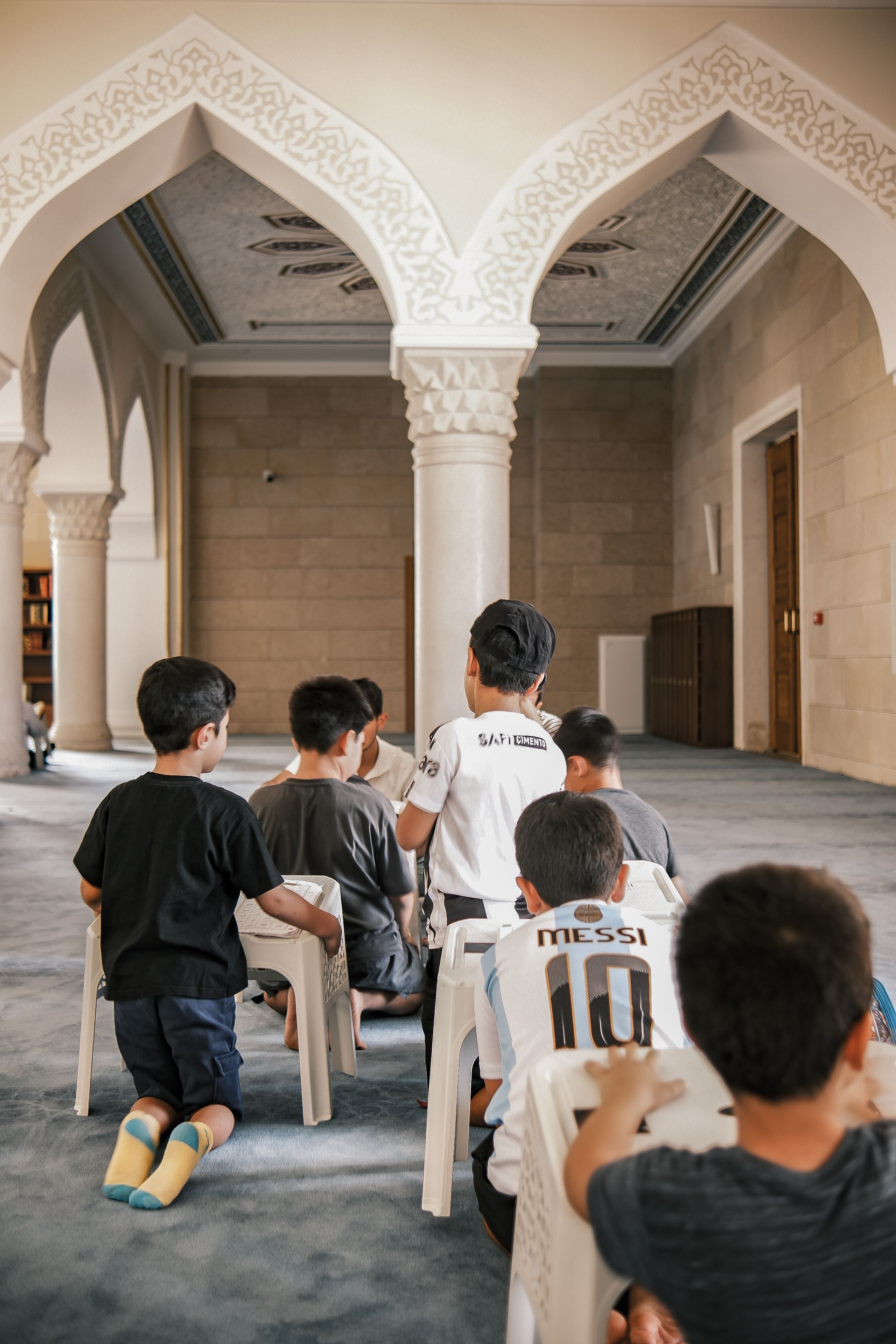 Child in Sports Jersey Inside Mosque Setting · Free Stock Photo