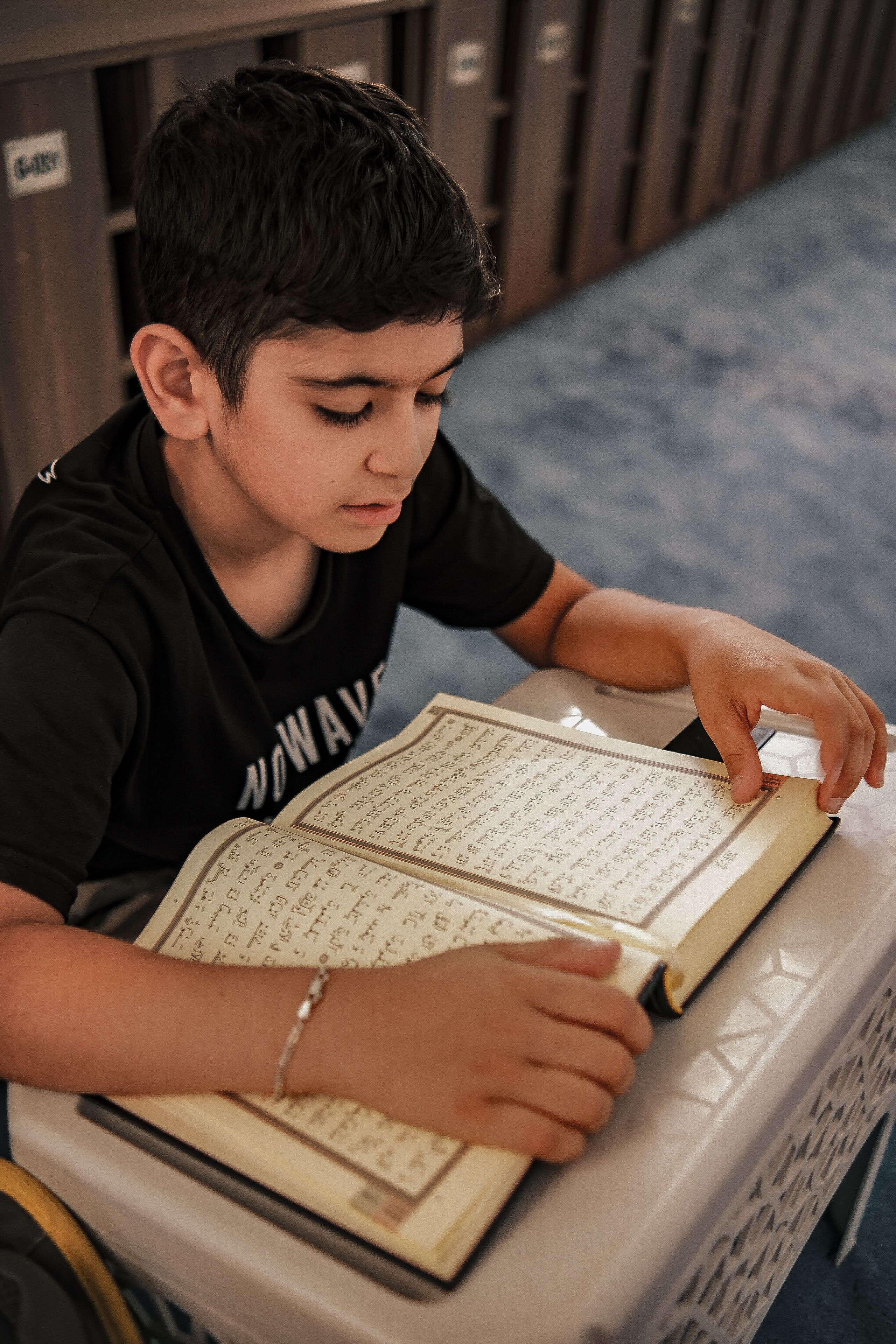 Child Reading Religious Text Indoors · Free Stock Photo
