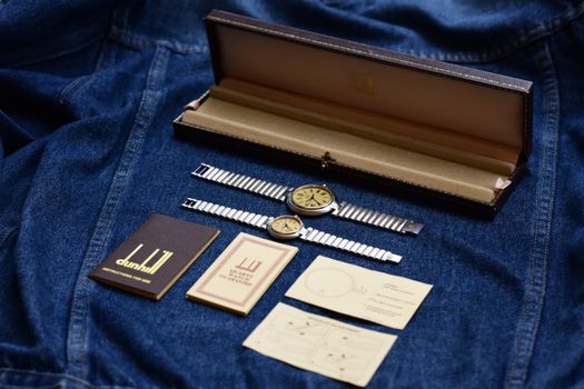 Elegant vintage Dunhill watch set displayed on a denim fabric with original packaging and inserts.
