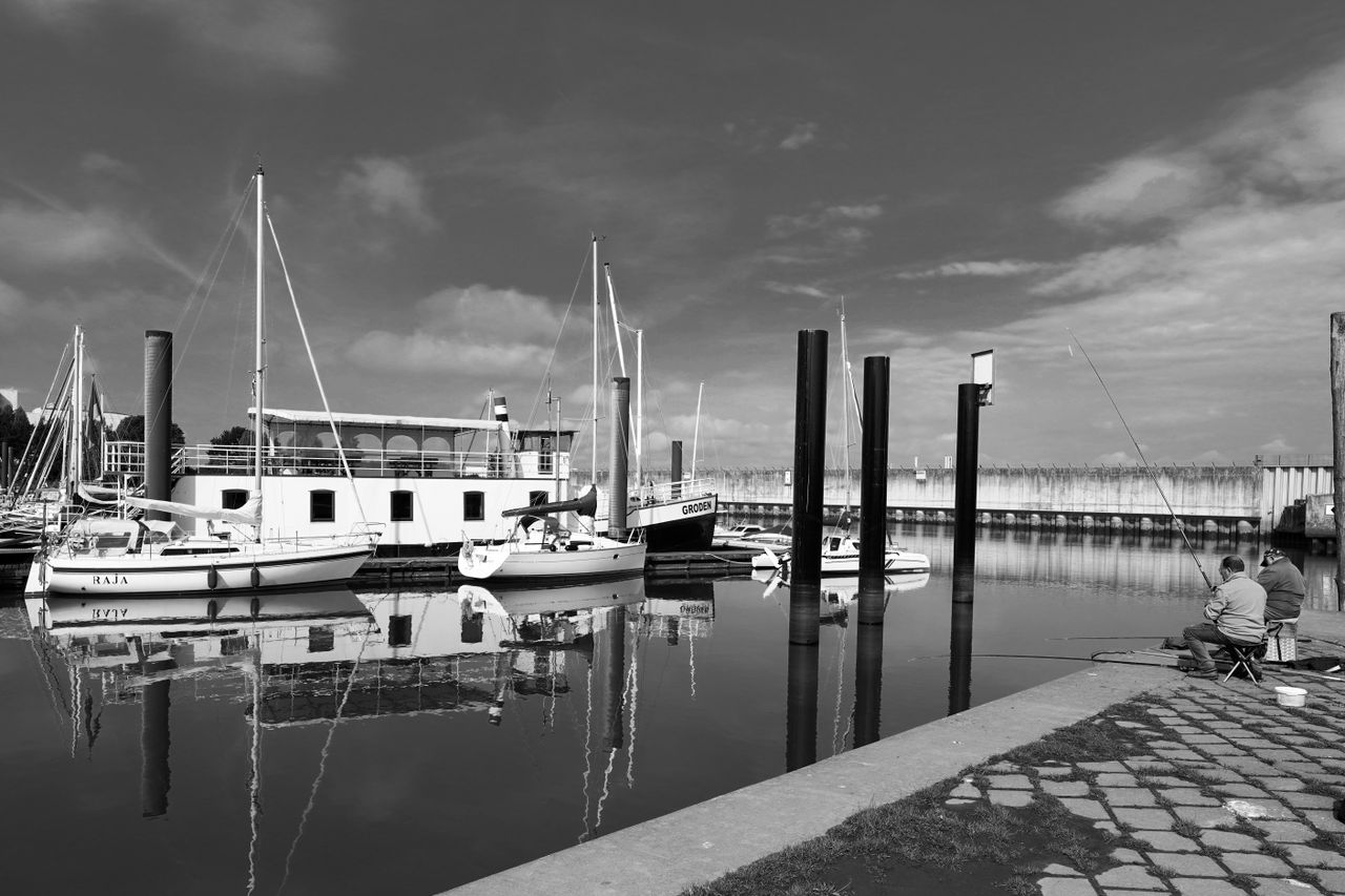 peaceful harbour view with docked boats and fishermen in hamburg germa