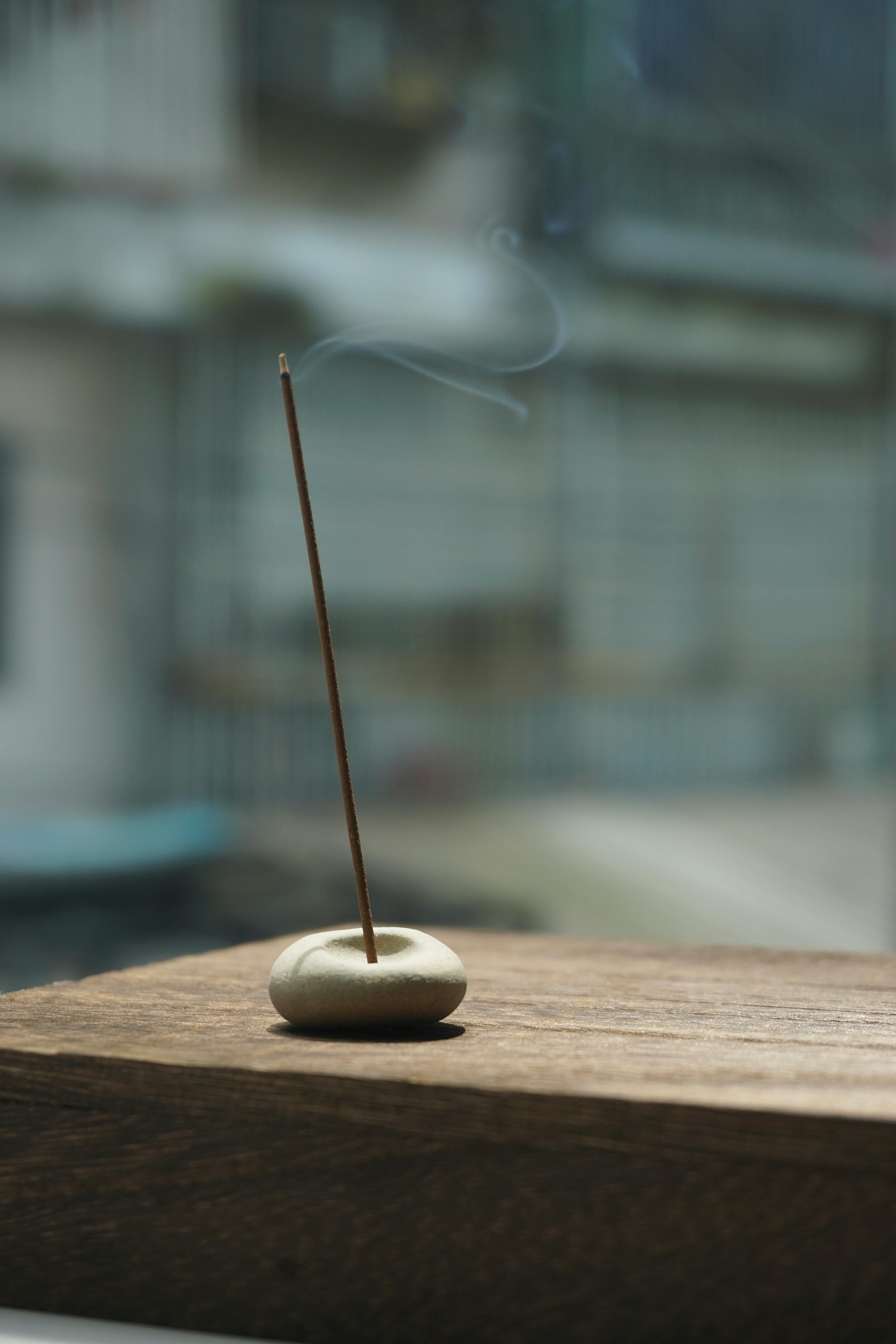 Gratis Fredelig scene av en brennende røkelsespinne på treflate utendørs. Arkivbilde