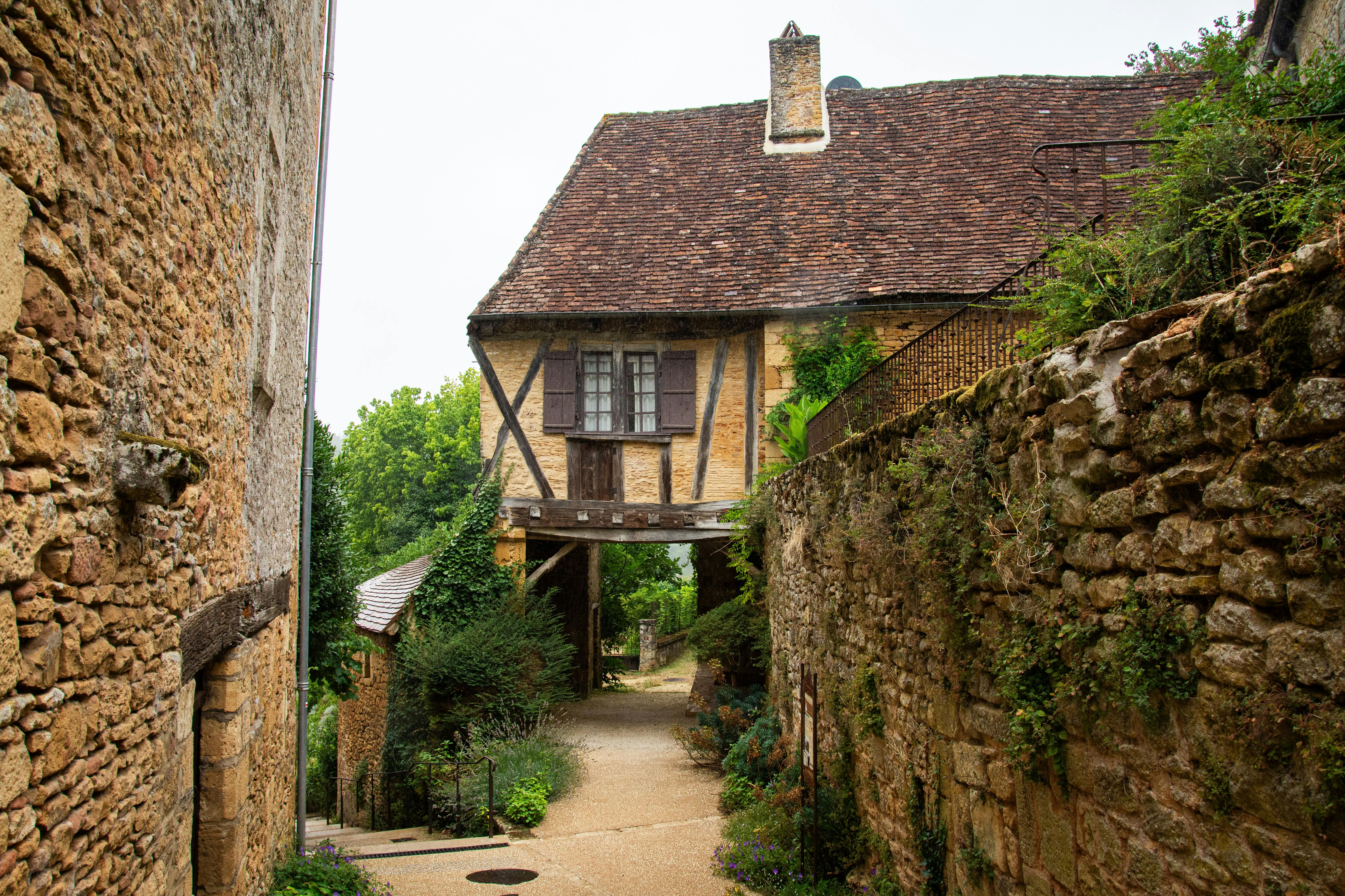 Maison en pierre pittoresque et sentier dans un pittoresque village français.