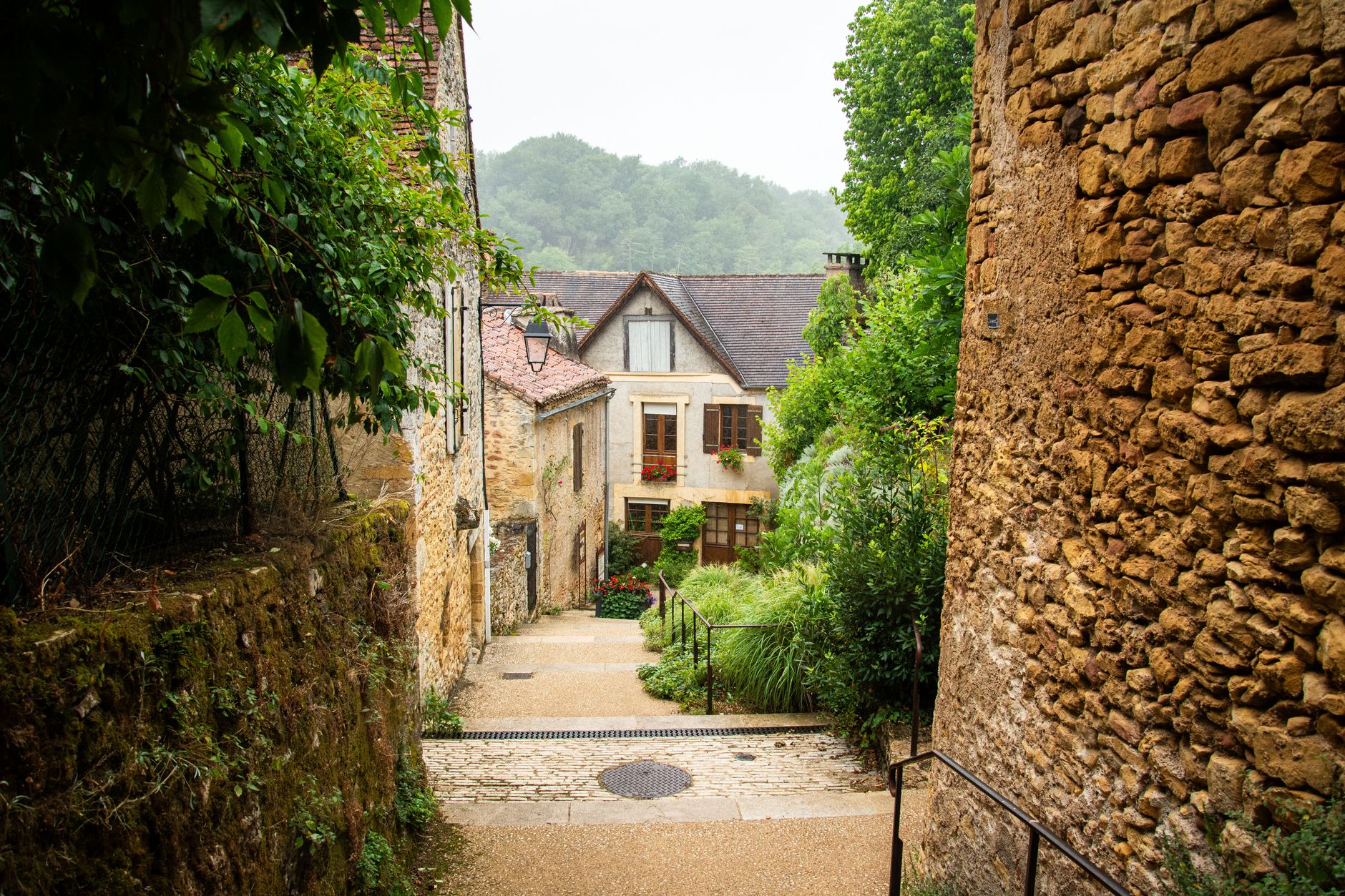 Explore a quaint village alleyway in Nouvelle-Aquitaine, France, surrounded by charming stone architecture.