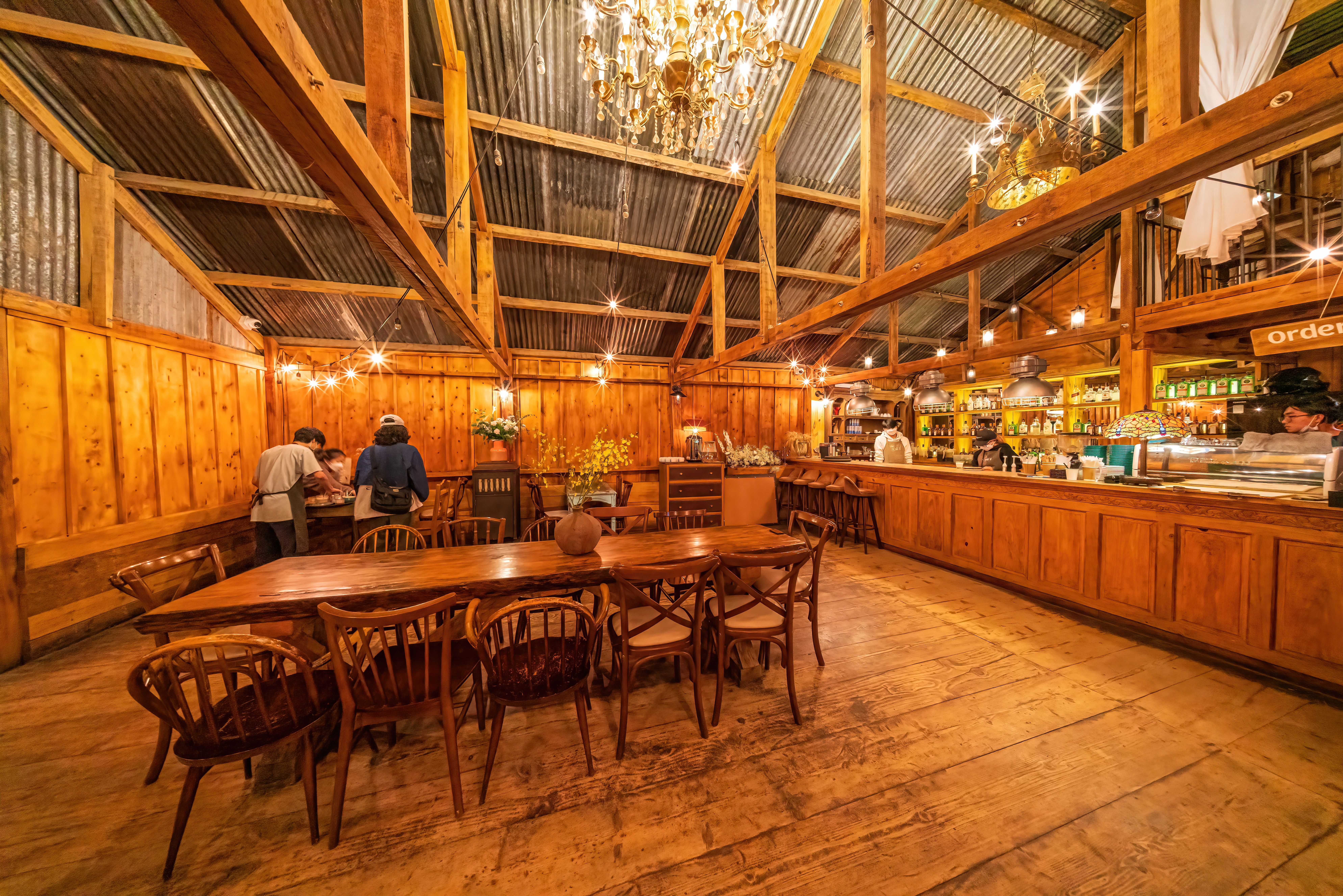 Cozy rustic cafe interior with warm wooden decor and soft amber lighting