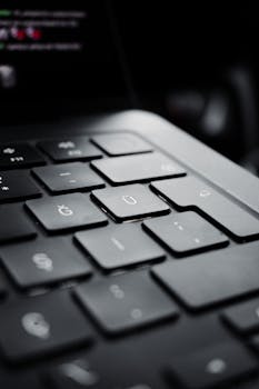Detailed view of a modern black laptop keyboard emphasizing the U key.