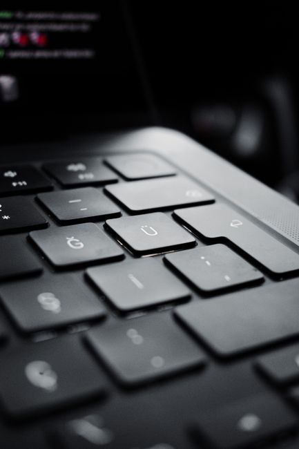 Detailed view of a modern black laptop keyboard emphasizing the U key.