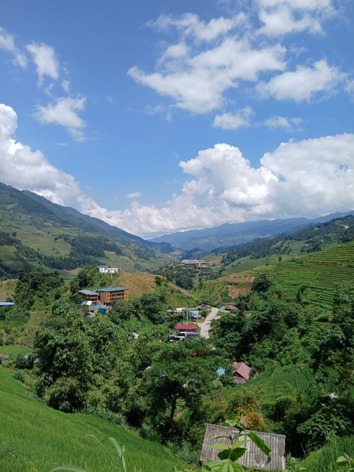 Free Stunning view of green valleys and mountains under a bright blue sky with fluffy clouds. Stock Photo