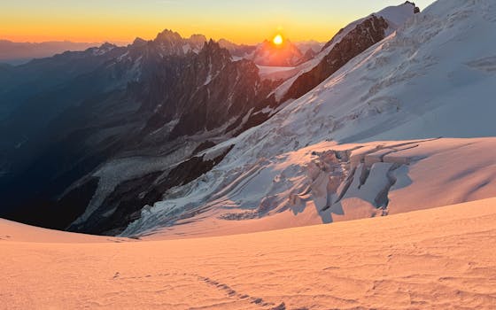 Experience the majestic sunrise over snow-covered slopes in Chamonix, France, capturing nature's beauty.