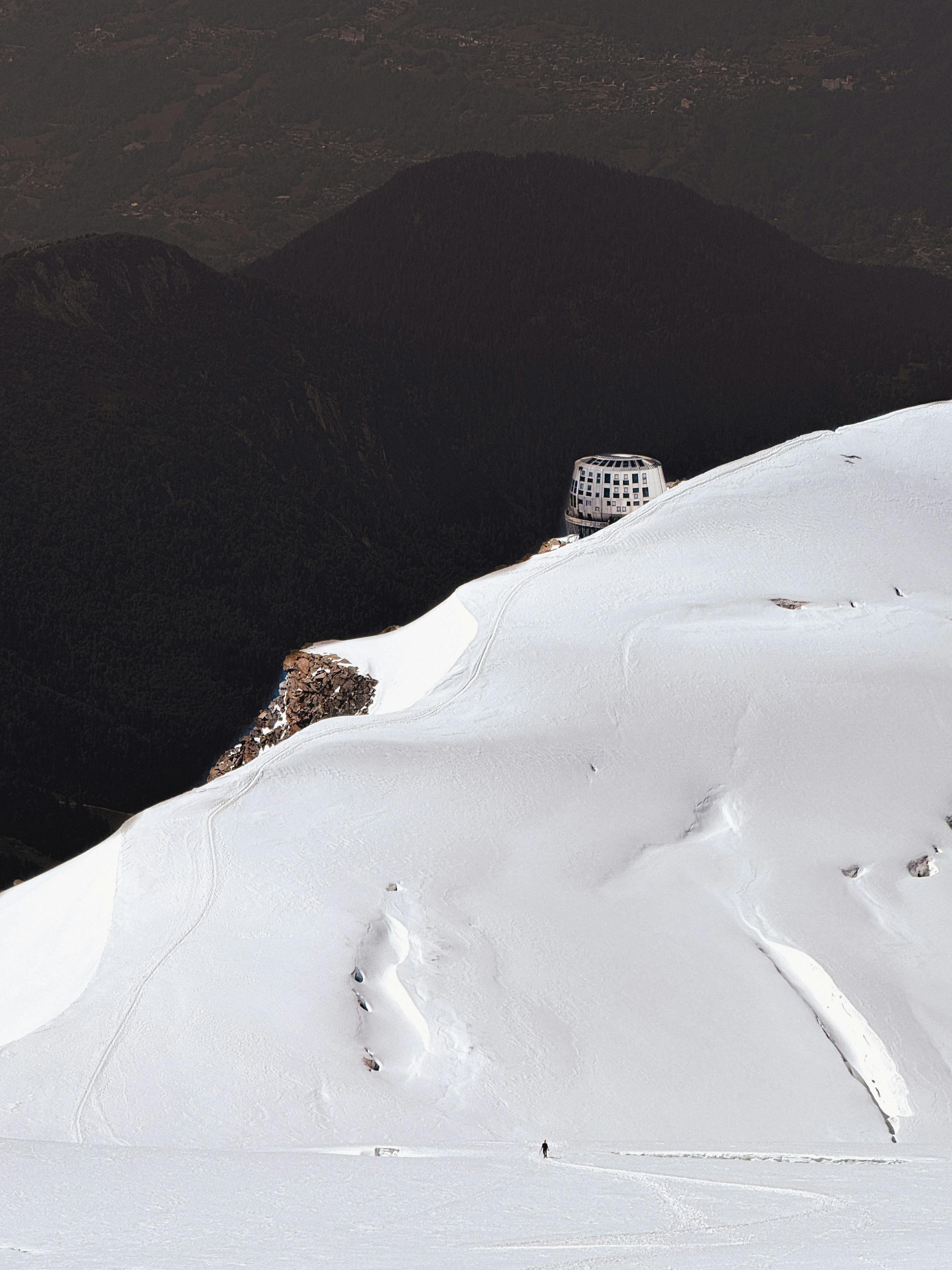 A remote mountain hut on a snowy slope in Chamonix, France, with dramatic alpine views.