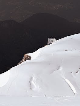 A remote mountain hut on a snowy slope in Chamonix, France, with dramatic alpine views.