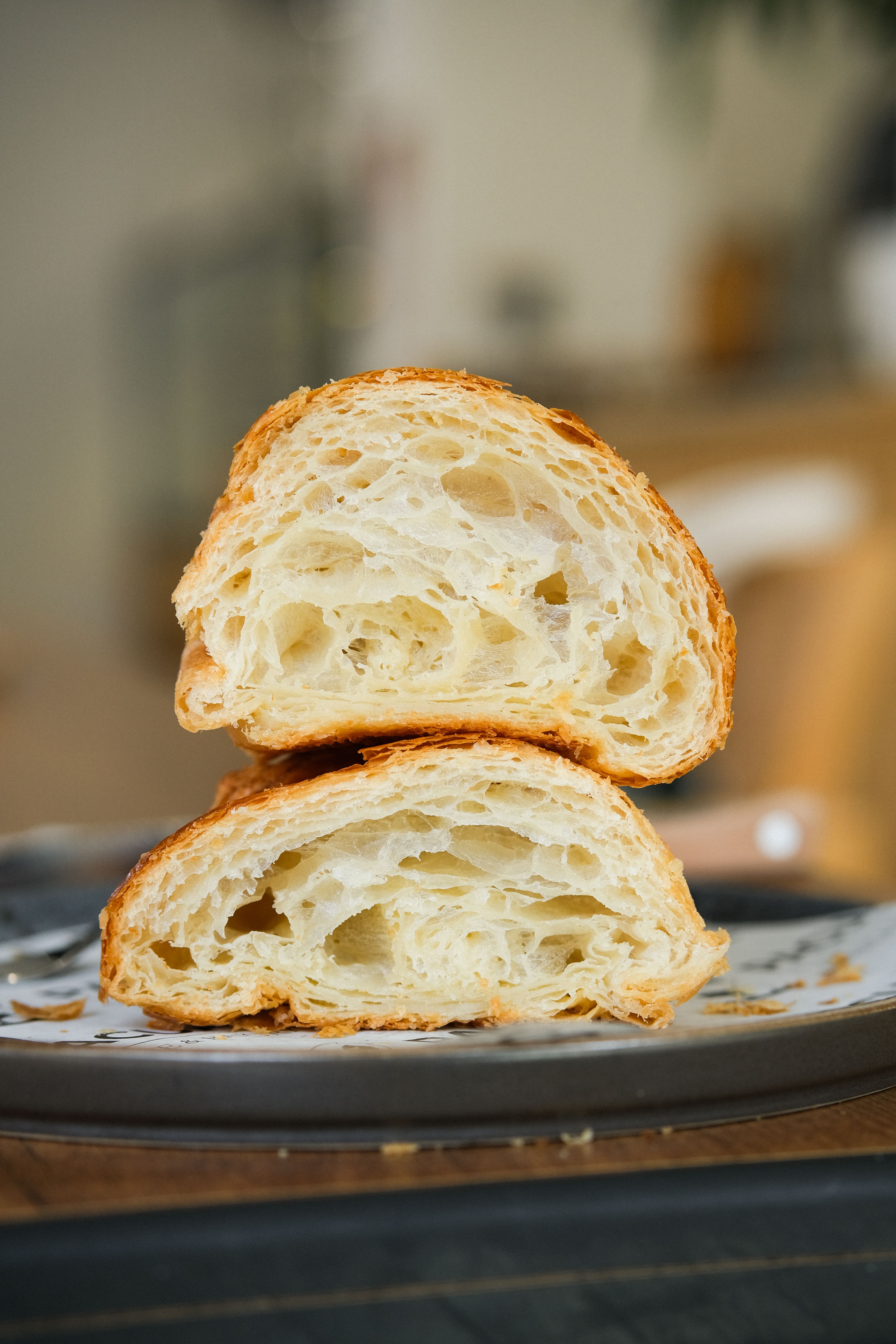 Delicious freshly baked croissant halves showcasing flaky layers, captured indoors.