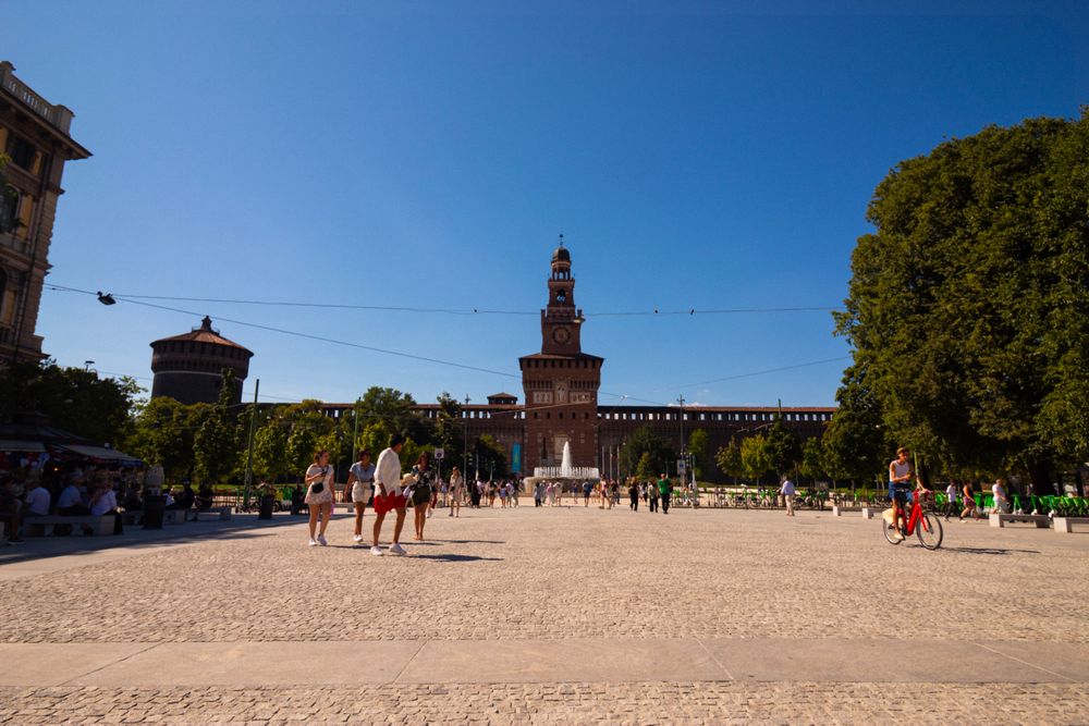 Oameni bucurându-se de o zi însorită la Castelul Sforzesco din Milano