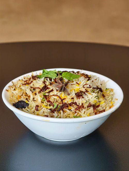 Free A flavorful biryani dish garnished with herbs and spices, perfect for food lovers. Stock Photo