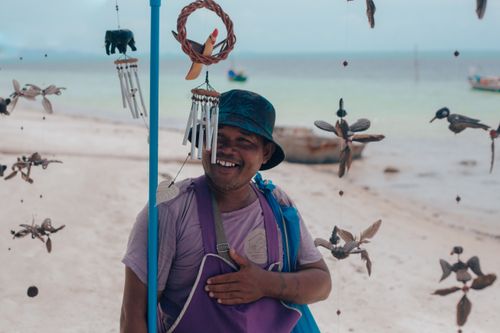 Free A cheerful vendor selling handmade crafts on a beautiful Samui beach in Thailand. Stock Photo