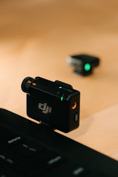 Close-up of a black wireless microphone attached to a laptop, suitable for podcast and video recording.