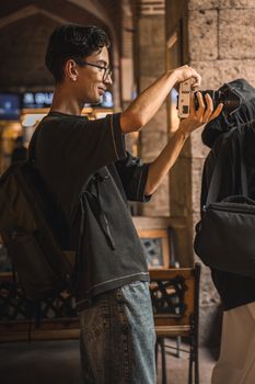 A young adult captures a moment outdoors in a modern urban setting with natural lighting.