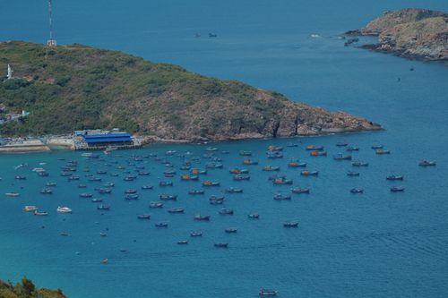 Free Captivating aerial view of vibrant boats scattered across a turquoise bay near rocky island. Stock Photo
