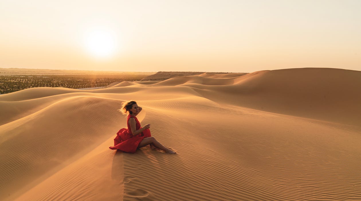 Free Foto Der Frau, Die Auf Sand Sitzt Stock Photo