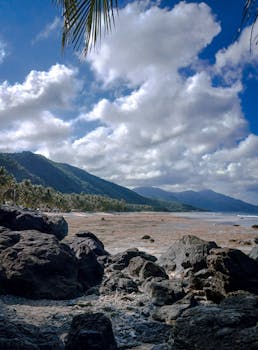Discover the stunning beach and scenic mountain views in the Philippines, under a vibrant sky.