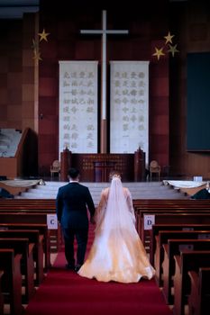 A bride and groom walking down the aisle inside an ornate church during their wedding ceremony.